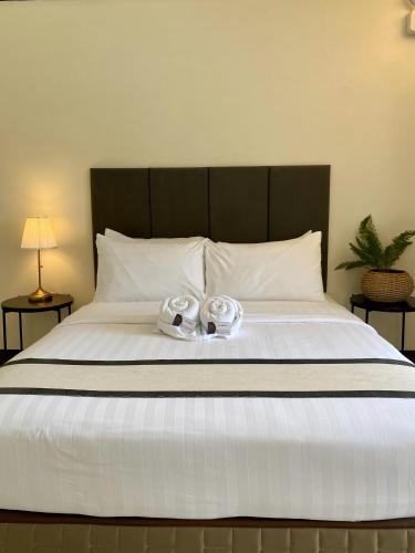 a bed with two slippers on top of it at Plaza Del Norte Hotel and Convention Center in Laoag