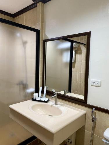 a bathroom with a sink and a mirror at Plaza Del Norte Hotel and Convention Center in Laoag