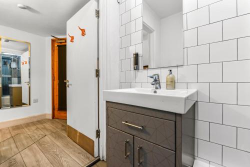 a bathroom with a sink and a mirror at Cosy studio flat on a budget in London