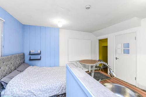 ein Badezimmer mit einem Waschbecken, einem Bett und einer Badewanne in der Unterkunft Cosy studio flat on a budget in London