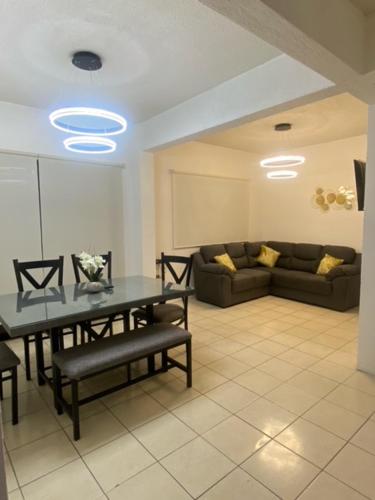 a living room with a table and a couch at HERMOSA CASA PRIVADA EN FRACC VALLE VERDE, AL SUR DE LA CIUDAD. in Tapachula