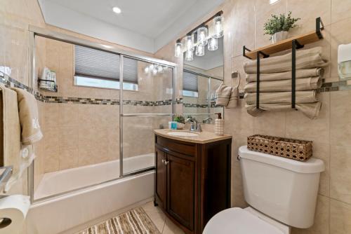 a bathroom with a toilet and a shower and a sink at Paradise Villa!!! Heated Pool, Games,10 min to Palm Beach & Airport in West Palm Beach