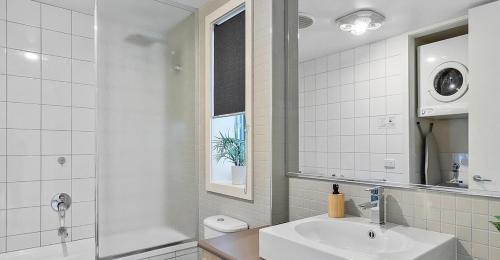 a white bathroom with a sink and a mirror at MURRAY GRANGE VILLA 4 in Yarrawonga