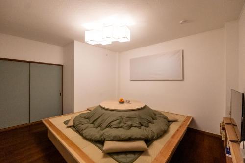 a room with a bed on a wooden table at sumica apartments in Nikko