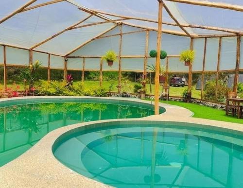 a large swimming pool in a large building at Orquideas Runtun in Baños