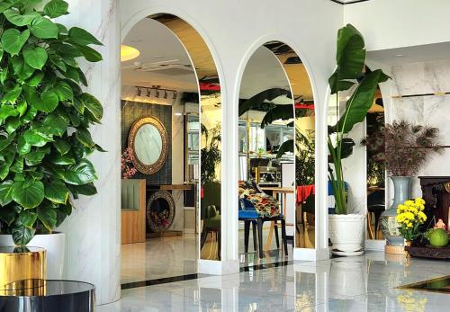 un vestíbulo con arcos y macetas en TIFFANY HOTEL & RESTAURANT en Phan Thiet