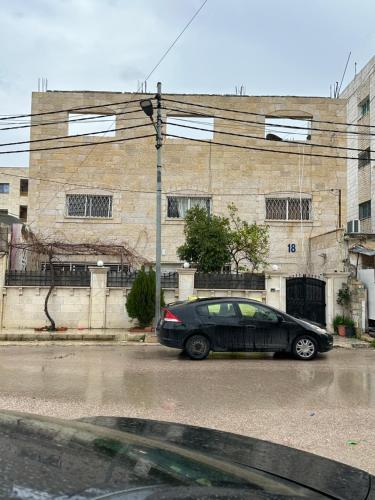 a black car parked in front of a building at Furnished studio with private entrance in Irbid