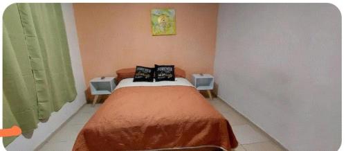 a small bedroom with a bed with two tables at Departamento cerca de la playa in Puerto Vallarta