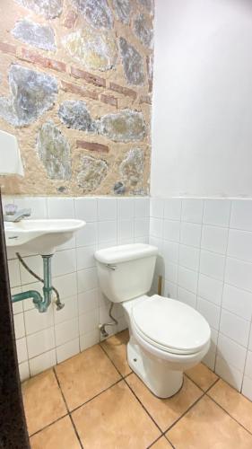 a bathroom with a white toilet and a sink at Hotel y Restaurante San Fernando. in Jocotenango