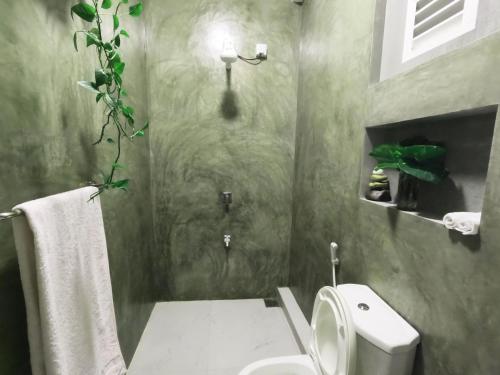 a bathroom with a white toilet and a shower at Pretty Villa in Gelioya
