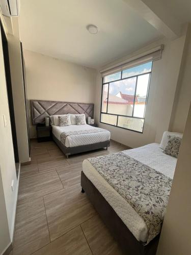 a bedroom with two beds and a window at Hotel Le Falep & Spa in Anapoima