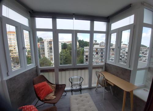 a room with windows and a table and chairs at Montebella at Portuguese Riviera ESTORIL in Estoril