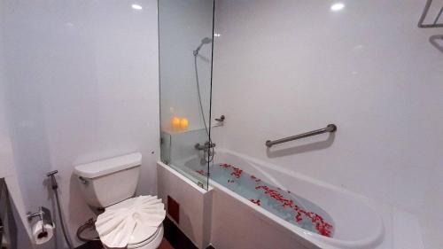 y baño con aseo y bañera. en Ruean Phae Royal Park Hotel, en Phitsanulok