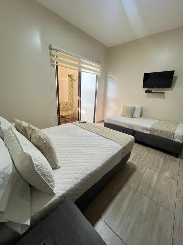 a bedroom with two beds and a flat screen tv at Hotel Le Falep & Spa in Anapoima