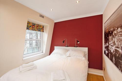 a bedroom with red walls and a white bed at Perfect Perch for Legal Eagle - Winchester Law Courts, High St, Westgate Museum in Winchester