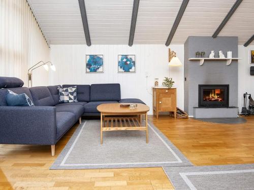 a living room with a blue couch and a fireplace at Secluded Haven in Rindby in Fanø