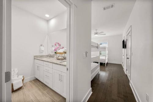a white bathroom with a sink and a mirror at Sandy Serenity Retreat in Panama City Beach