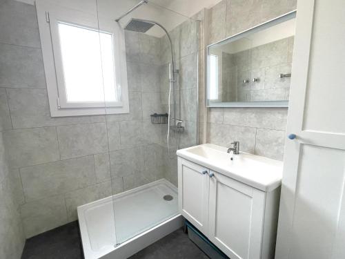 une salle de bain blanche avec un lavabo et une douche dans l'établissement Maison rénovée 3 ch. proche mer, animaux admis, terrasse et parking - FR-1-231-290, à Bretignolles-sur-Mer