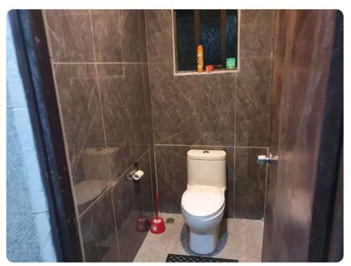 łazienka z toaletą i ścianą wyłożoną kafelkami w obiekcie Seaside Homes w mieście Nadi