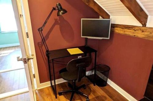 een bureau met een computer en een lamp in een kamer bij Walkable Elmwood Cottage, No Chores 4Bath 4BR 4Car in Buffalo
