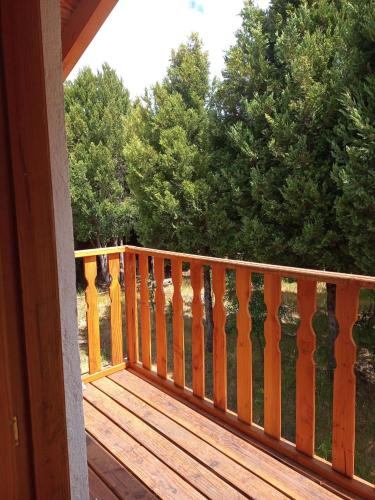 a wooden deck with a railing on a house at chacra EL PORTAL in Epuyén