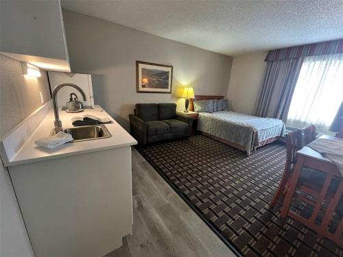 um quarto de hotel com um lavatório e um quarto em FairBridge Extended Stay, a Kitchenette Hotel em Idaho Falls