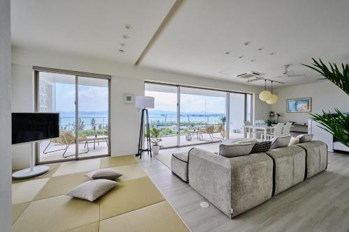a living room with a couch and a television at 青風 Aokaji 古宇利島のプール付き一棟ヴィラ in Kouri
