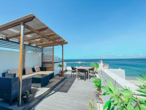einen Balkon mit einem Tisch und Meerblick in der Unterkunft Casa Marco Suites Puerto Galera powered by Cocotel in Puerto Galera
