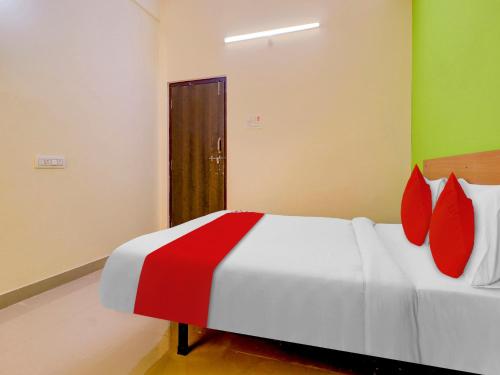 1 dormitorio con cama blanca y almohadas rojas en Hotel RBS NFC Road, en Maula Ali