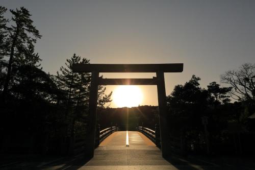 a torii gate on a bridge with the sunset at Grand Mercure Ise-shima Resort & Spa in Shima