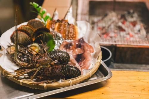 a tray of food with seafood on a table at Grand Mercure Ise-shima Resort & Spa in Shima