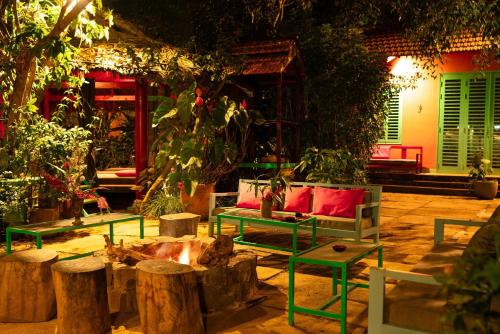 a patio with benches and tables and trees at Ivory Falls Villa in Di Linh