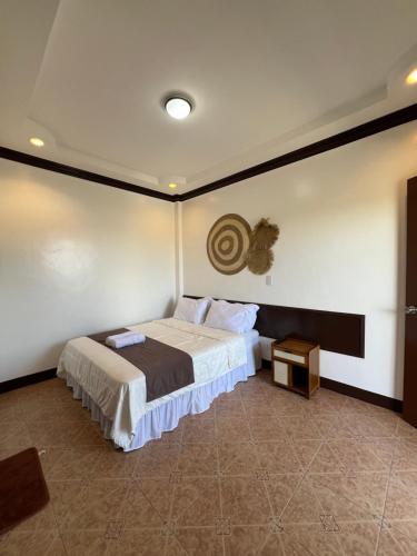 1 dormitorio con 1 cama grande y 1 mesa en Oceana Bay Coron, en Corón