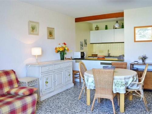 une cuisine et un salon avec une table et des chaises dans l'établissement Appartement avec Piscine, Tennis et Parking au Lavandou - 2 Pièces, 4 Couchages - FR-1-251-24, au Lavandou