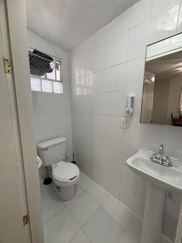 エンセナダにあるCasa Vivancoのトイレと洗面台を備えた白いバスルーム
