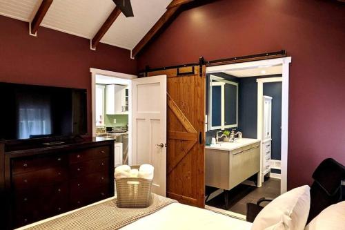 a bedroom with a large door leading to a bathroom at Walkable Elmwood Cottage, No Chores 2Bath 2BR 1Car in Buffalo