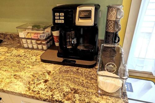 a counter top with a coffee maker and a glass bottle at Walkable Elmwood Cottage, No Chores 2Bath 2BR 1Car in Buffalo