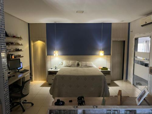 een slaapkamer met een bed, een bureau en een bad bij ACONCHEGANTE (SUITE) in Rio Verde