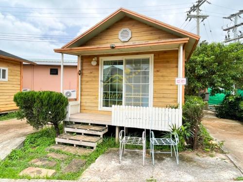 a tiny house with two chairs and a porch at Goldengold (Khaoyai) Resort & Spa in Mu Si