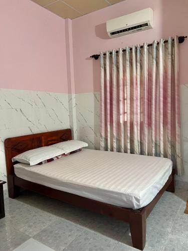 a bedroom with a bed and a window at Thao Vi Guest House Duc Thao in Mui Ne