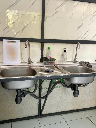 a kitchen sink with two faucets on a counter at Thao Vi Guest House Duc Thao in Mui Ne