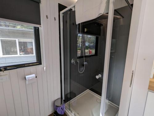 a shower with a glass door in a bathroom at Tiny House 22 at Grampians Edge in Dadswells Bridge