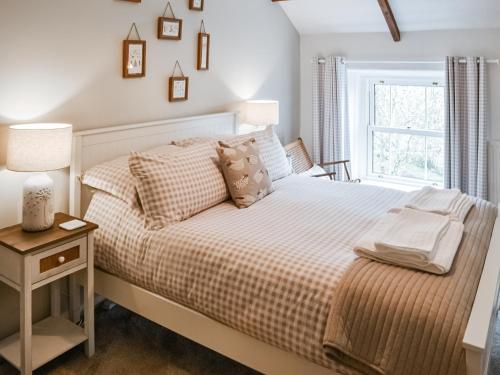 a bedroom with a bed and a window at Middles Cottage in West Woodburn