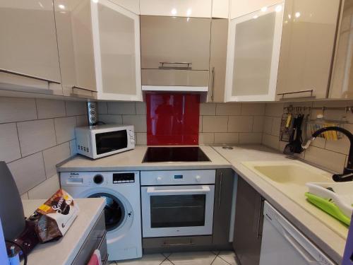 une cuisine avec un lave-linge et un micro-ondes dans l'établissement Appartement Climatisé avec Parking Privé à 450m des Plages d'Argelès-sur-Mer - FR-1-776-76, à Argelès-sur-Mer