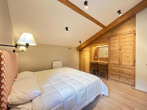 une chambre avec un lit blanc et un bureau dans l'établissement Appartement de standing - 3 chambres, balcons, garage, proche centre et remontées mécaniques - FR-1-623-357, aux Gets