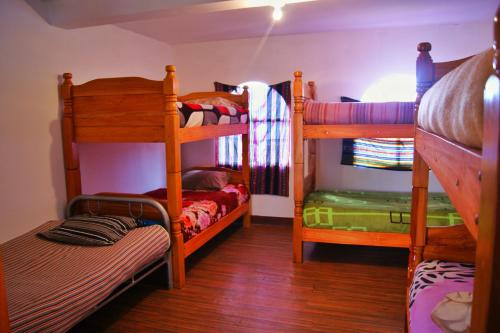 PeñasにあるHostal Ancohumaの二段ベッド2台とベッド1台が備わる客室です。