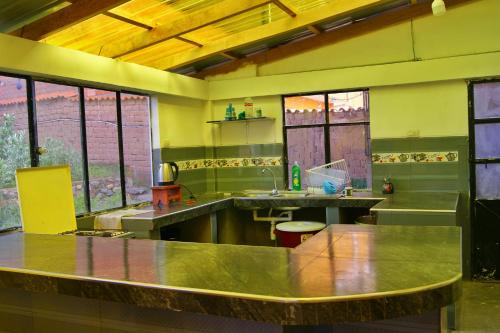 a large kitchen with a large steel counter top at Hostal Ancohuma in Peñas
