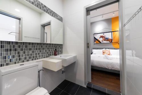 ein Bad mit einem Waschbecken, einer Badewanne und einem Bett in der Unterkunft HighPark Suites by Sleepy Bear in Petaling Jaya