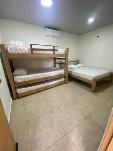 a room with two bunk beds and a tile floor at CABAÑA LUJOSA CON MESA DE BILLAR in Sabanagrande