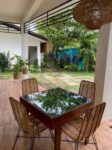 a dining room table with chairs and a glass top at Bahandi Hotel in General Luna